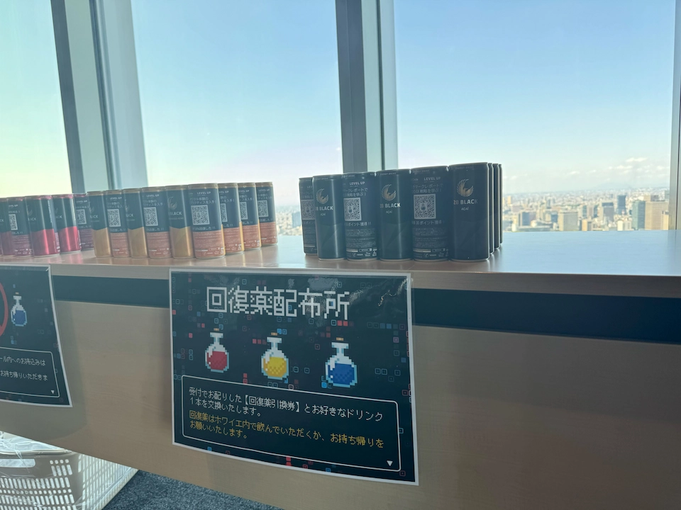 イベント会場でRPGの世界観を演出するため、「回復薬配布所」と書かれた看板と並べられた28 BLACKオリジナルラベルのエナジードリンク缶