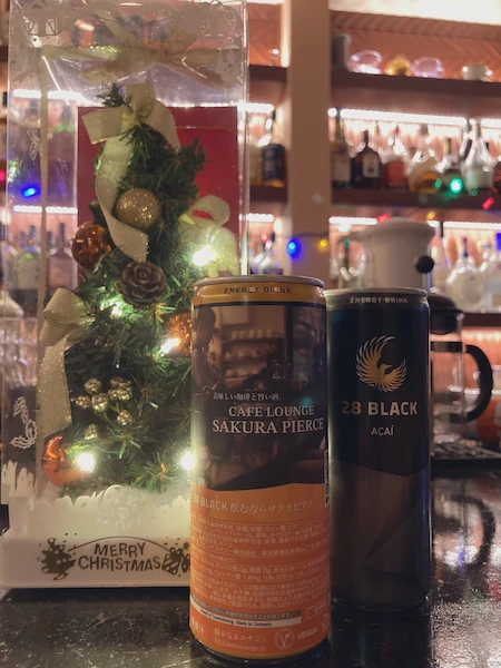 サクラピアスオリジナルラベルエナジィとクリスマスデコレーション。店内のカウンターに置かれた28 BLACKオリジナルラベルと通常版の缶が並んでいる